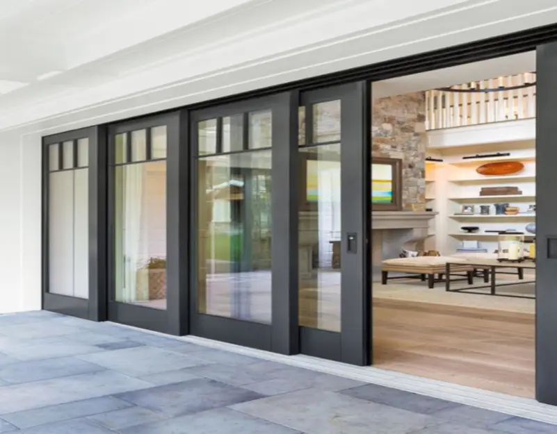 Black-framed multi-panel sliding impact glass doors on a covered patio