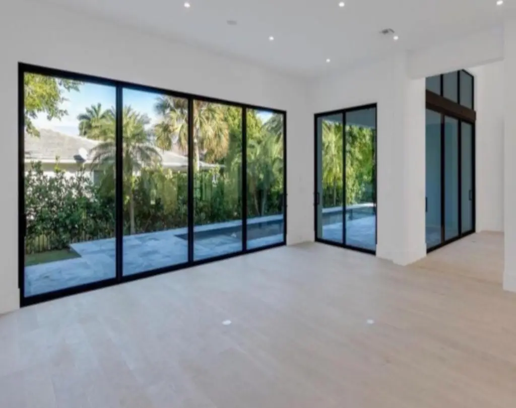 Floor-to-ceiling impact sliding doors overlooking a South Florida backyard